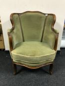 An early 20th century walnut framed armchair upholstered in a green fabric