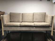 A beech framed three seater settee upholstered in brown fabric