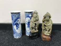 A pair of Oriental soapstone figures on stands together with a pair of twentieth century blue and