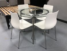 A contemporary circular glass topped table on chrome base together with four white chairs on chrome