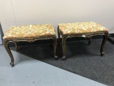 A pair of carved walnut dressing table stools