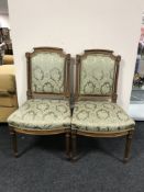 A set of four late nineteenth century carved walnut dining chairs upholstered in green floral