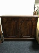 A reproduction mahogany double door cupboard