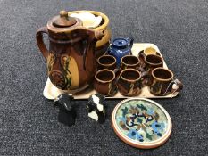 A tray of assorted pottery including cows head, salt and pepper sellers, water jug with six mugs,