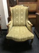 A carved walnut framed armchair upholstered in a striped brocade
