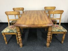 A contemporary pine kitchen table together with four chairs
