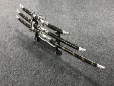 A set of three graduated samurai style swords on stands with scabbards