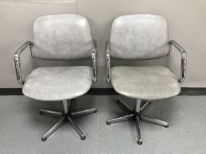A pair of chrome framed swivel armchairs upholstered in grey vinyl
