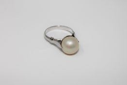 A large pearl ring, the 11mm pearl set in white metal with foreign marks to outside of shank,
