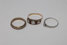 A 9ct gold opal and garnet ring, a diamond solitaire ring and an eternity ring, 5.