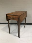 A mahogany drop leaf kitchen table fitted with a drawer