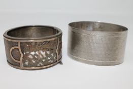 Two antique silver bangles with Birmingham marks; the first with engine turned decoration,