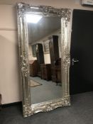 An ornate silvered rectangular mirror, 204 cm x 102 cm