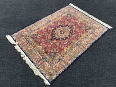 A silk finished fringed rug on blue ground