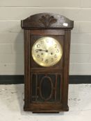 An oak cased wall clock with silvered dial