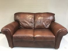 A pair of brown leather two seater settees