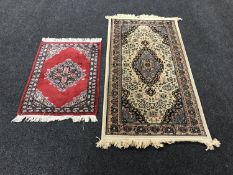 A fringed woollen rug on cream ground and one other rug