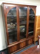 A mahogany triple door display cabinet