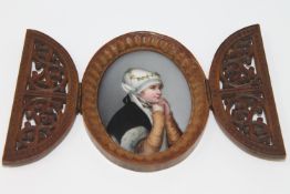 An antique wooden framed painted porcelain plaque depicting a young girl