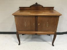 An early 20th century mahogany serving cabinet with inlaid doors