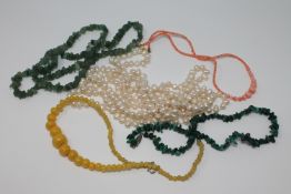 A group of five necklaces to include a large pearl example, jade, coral,