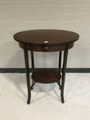 A circular mahogany two-tier work table