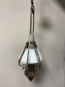 A contemporary brass light fitting in the form of a vintage oil lamp with glass shade and chimney