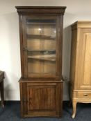 A late Victorian oak display cabinet fitted with cupboard beneath