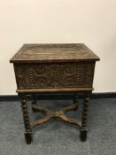 A continental carved oak antique box on stand with iron handles,