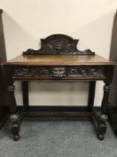 A Victorian carved oak side table fitted with a drawer,