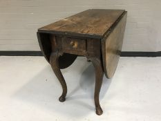 An antique oak drop leaf table fitted with a drawer