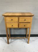 A mid 20th century oak side table fitted four drawers
