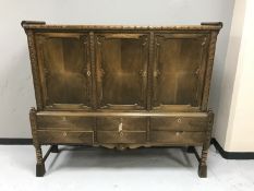 A twentieth century continental oak triple door sideboard fitted with six drawers