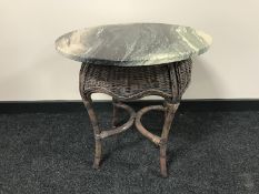 A circular wicker occasional table with a marble top