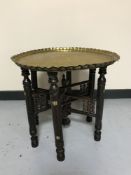 A folding eastern embossed brass topped table