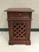 A contemporary bedside cabinet with lattice door in a mahogany finish