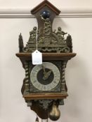 A continental wall clock with pendulum weights