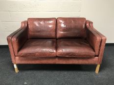 A Stouby two seater settee in burgandy leather