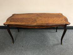 An inlaid French style coffee table on brass feet