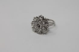 A diamond cluster ring, set with three tiers of 17 brilliant cut stones held within a claw setting,