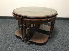 An inlaid mahogany glass topped coffee table fitted four tables beneath