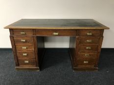 An early 20th century oak twin pedestal desk fitted with eleven drawers