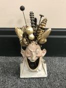 A continental bisque hat pin stand modelled after a man with an open mouth,