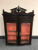 An early 20th century double glazed door wall cabinet