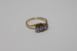 An 18ct gold three stone diamond twist ring,