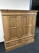 A pine triple door child's wardrobe fitted two drawers