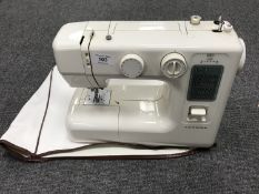 A Janome sewing machine in case and a boxed Quartz wall clock