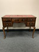 A mahogany leather topped writing desk fitted five drawers