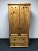 A pine double door wardrobe fitted with two drawers