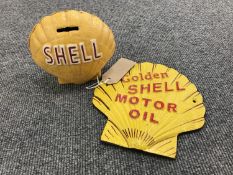 A cast iron shell money box together with a golden shell motor oil advertisement
